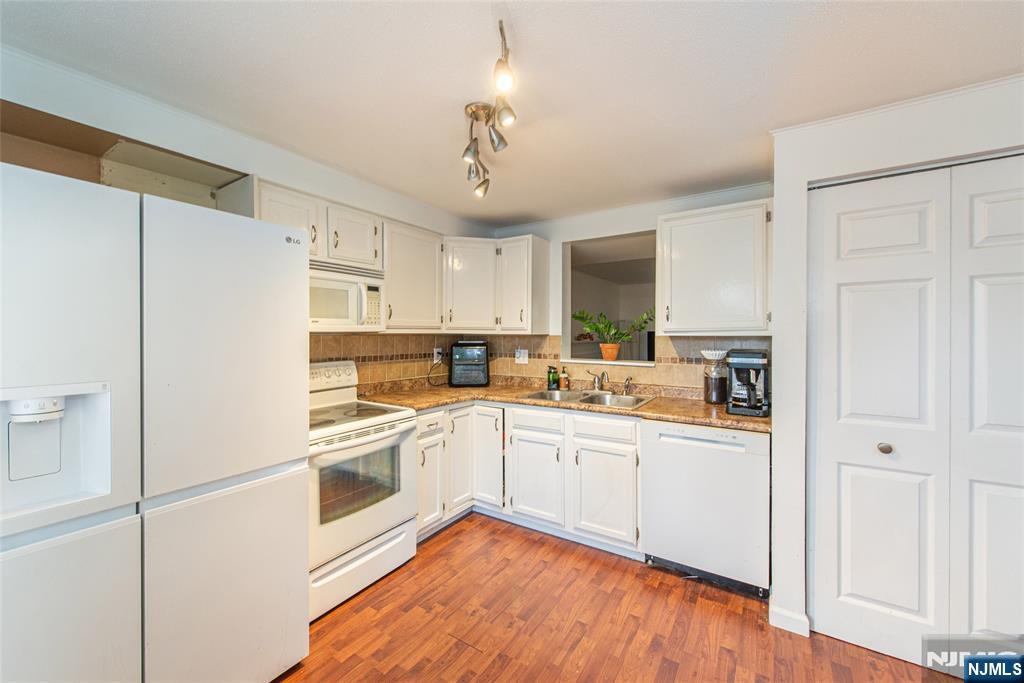 76 Constitution Way, Unit 534 Franklin, NJ 07416 - Photo 4 of 22 a kitchen with white cabinets and white appliances
