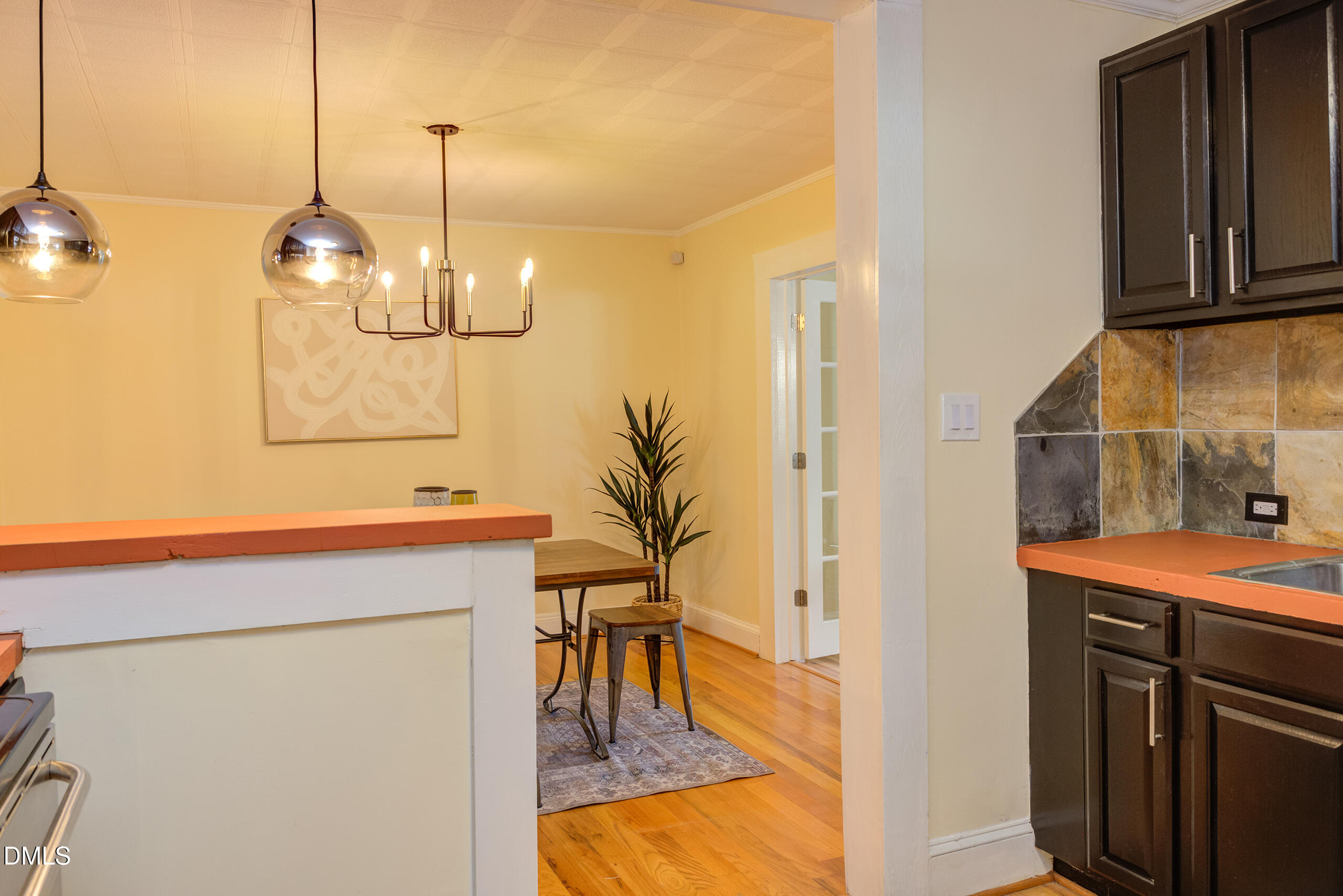 1109 North Elizabeth Street Durham, NC 27701 - Photo 20 of 44 a room with kitchen island a chandelier and wooden floor