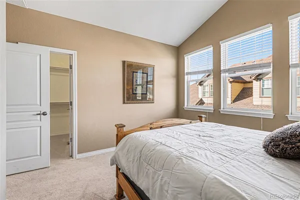 a living room with furniture two window and a wooden floor