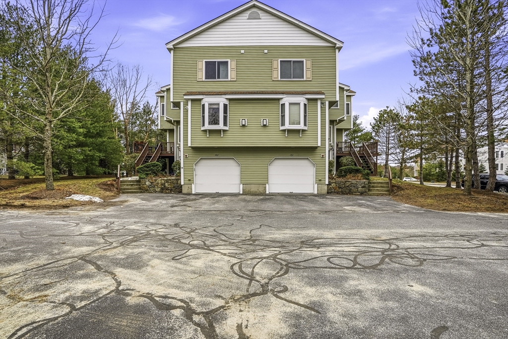 153 America Boulevard, Unit 153 Ashland, MA 01721 - Photo 2 of 42 a view of a white house with a yard and parking space