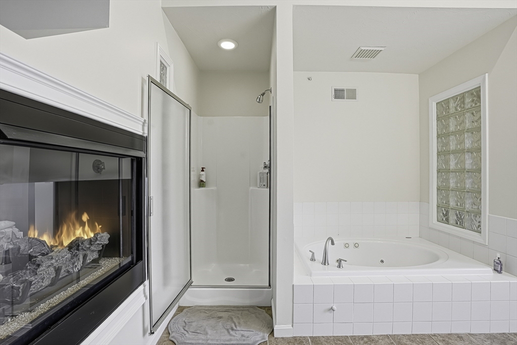 153 America Boulevard, Unit 153 Ashland, MA 01721 - Photo 31 of 42 a bathroom with a bathtub and a walk in closet