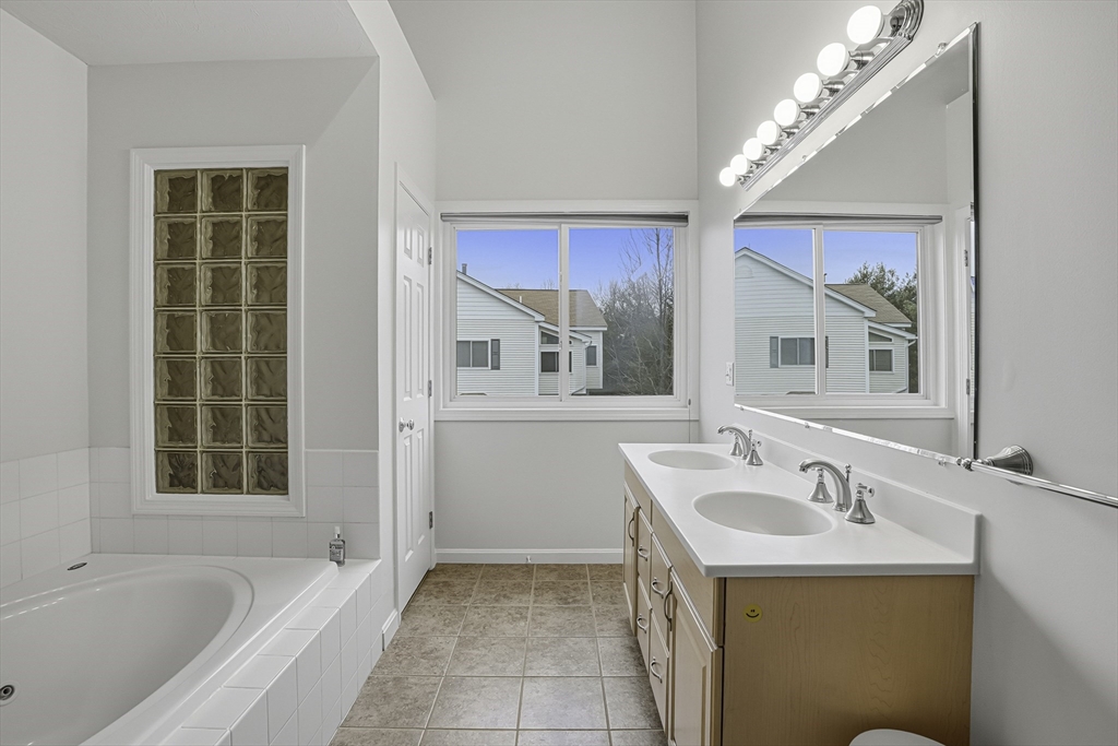 153 America Boulevard, Unit 153 Ashland, MA 01721 - Photo 32 of 42 a bathroom with a tub sink and mirror