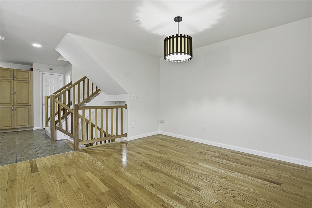 153 America Boulevard, Unit 153 Ashland, MA 01721 - Photo 8 of 42 a view of empty room with wooden floor