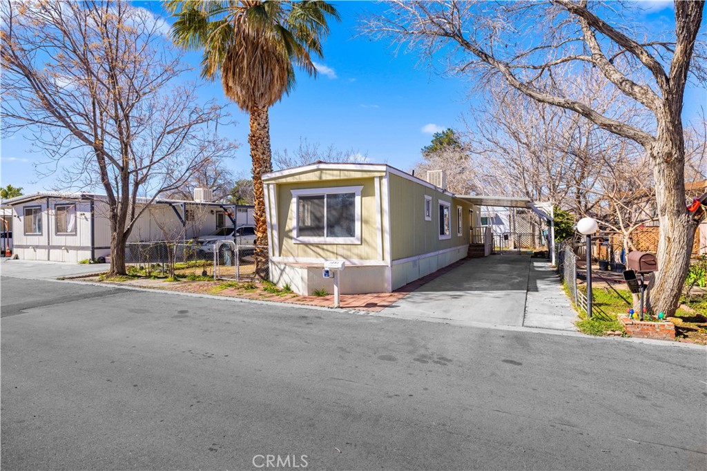 43850 20th Street East, Unit 265 Lancaster, CA 93535 - Photo 3 of 19 a view of a house with a yard and garage