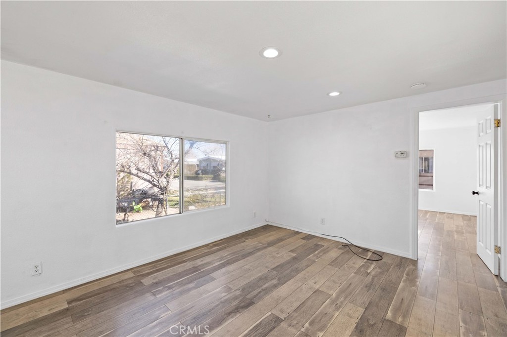 43850 20th Street East, Unit 265 Lancaster, CA 93535 - Photo 6 of 19 an empty room with wooden floor and windows