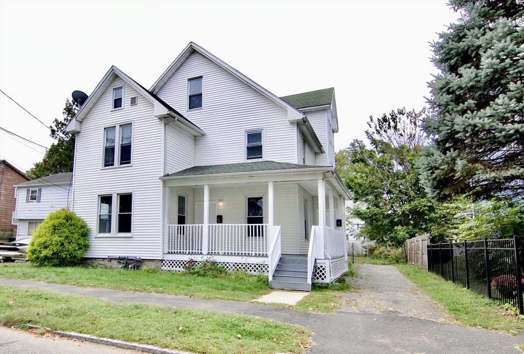 58 Howes Street, Unit 1 Springfield, MA 01118 - Photo 1 of 24 a front view of a house with a yard and garage
