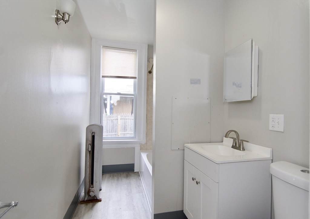 58 Howes Street, Unit 1 Springfield, MA 01118 - Photo 14 of 24 a bathroom with a sink a toilet and a window