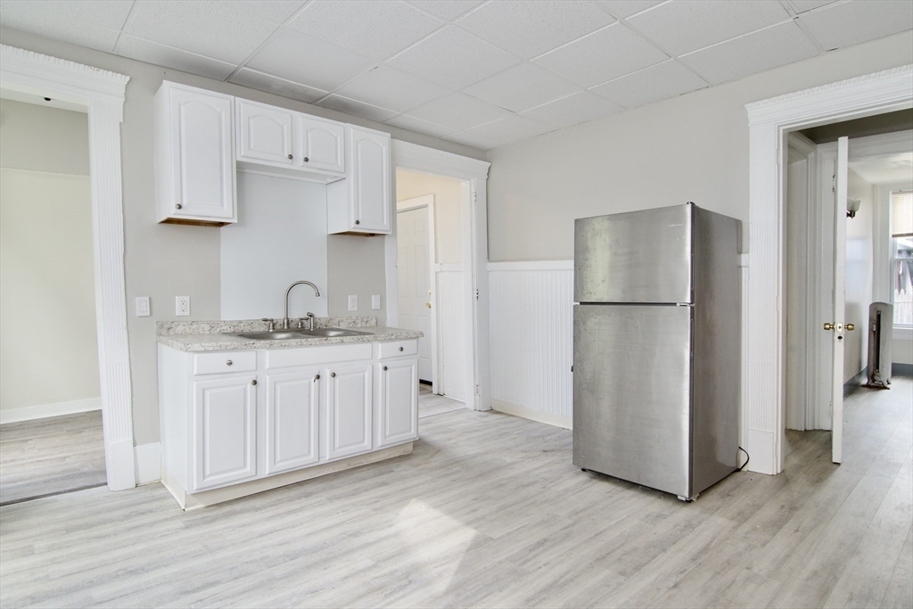 58 Howes Street, Unit 1 Springfield, MA 01118 - Photo 6 of 24 a kitchen with white cabinets and refrigerator