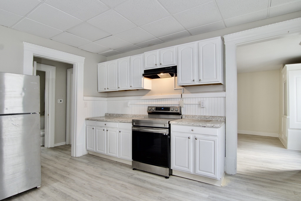 58 Howes Street, Unit 1 Springfield, MA 01118 - Photo 9 of 24 a kitchen with white cabinets and stainless steel appliances