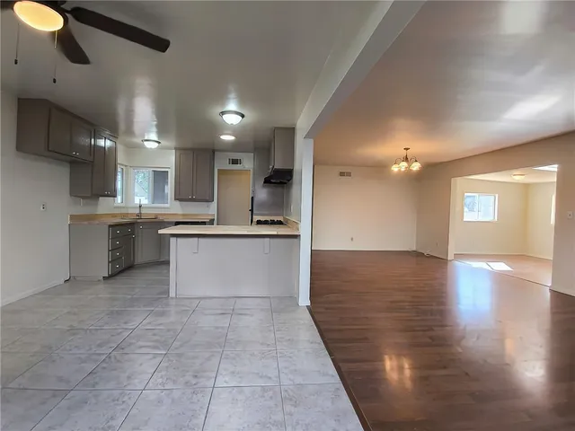 a large kitchen with stainless steel appliances granite countertop a sink and cabinets with wooden floor