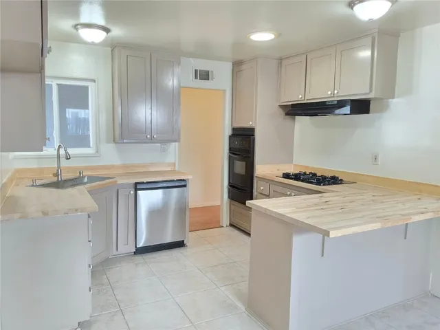 a kitchen with granite countertop a sink stove and refrigerator