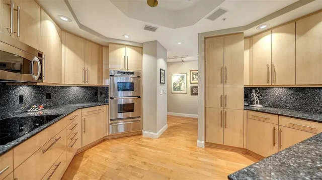 a kitchen with stainless steel appliances granite countertop a refrigerator and a sink