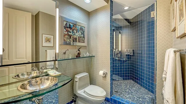 a bathroom with a sink a toilet and shower