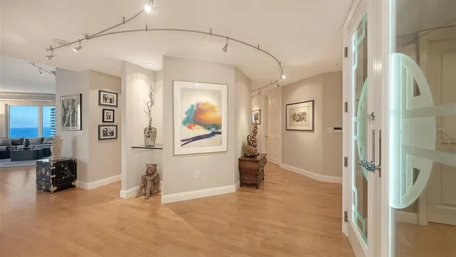 a view of hallway with livingroom and wooden floor