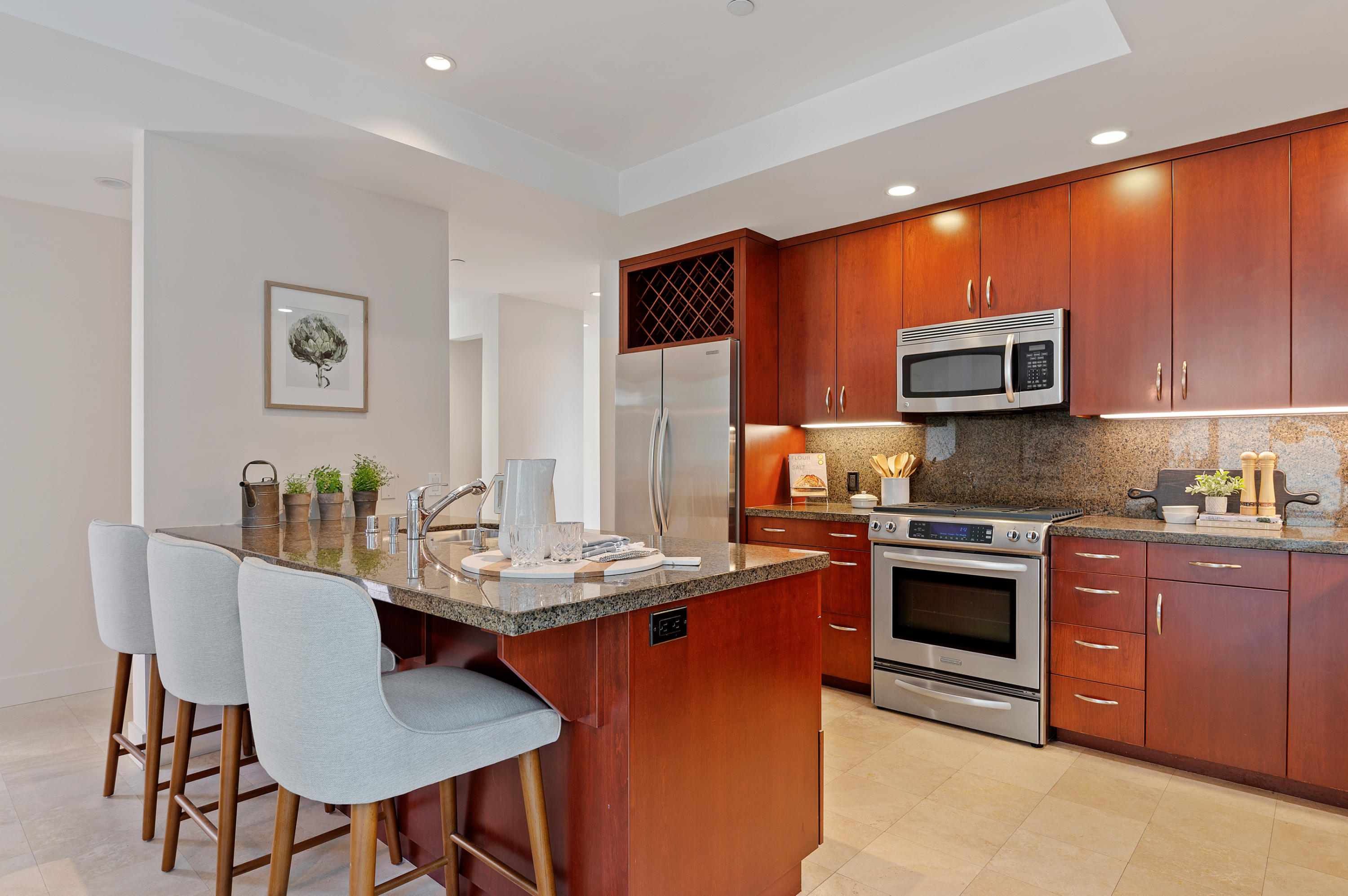 4815 Sandyland Road, Unit A Carpinteria, CA 93013 - Photo 9 of 29 a kitchen with stainless steel appliances granite countertop a stove top oven a sink a refrigerator with a dining table and chairs