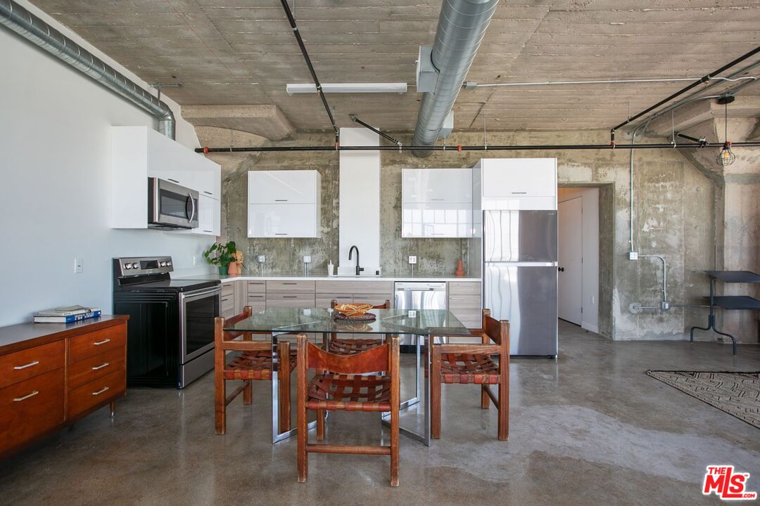 691 Mill Street, Unit 705 Los Angeles, CA 90021 - Photo 6 of 11 a kitchen with table chairs and refrigerator