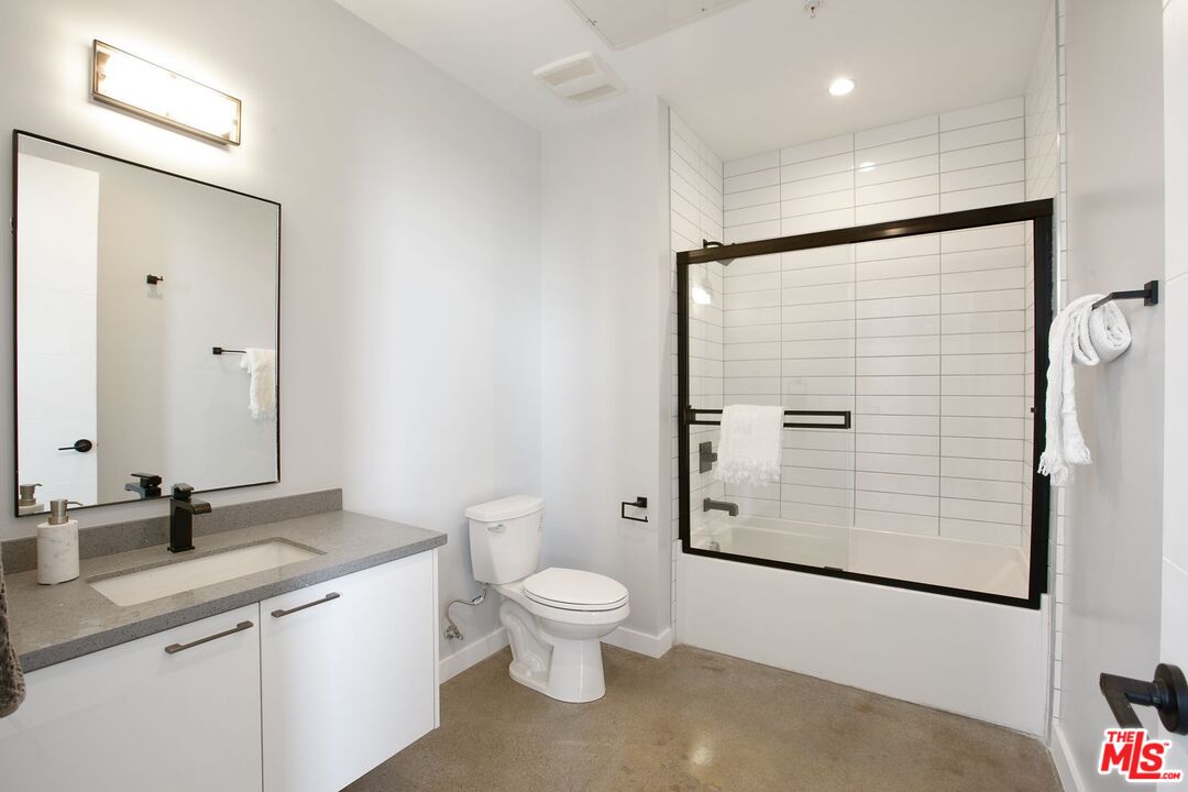 691 Mill Street, Unit 705 Los Angeles, CA 90021 - Photo 9 of 11 a bathroom with a granite countertop sink toilet and shower