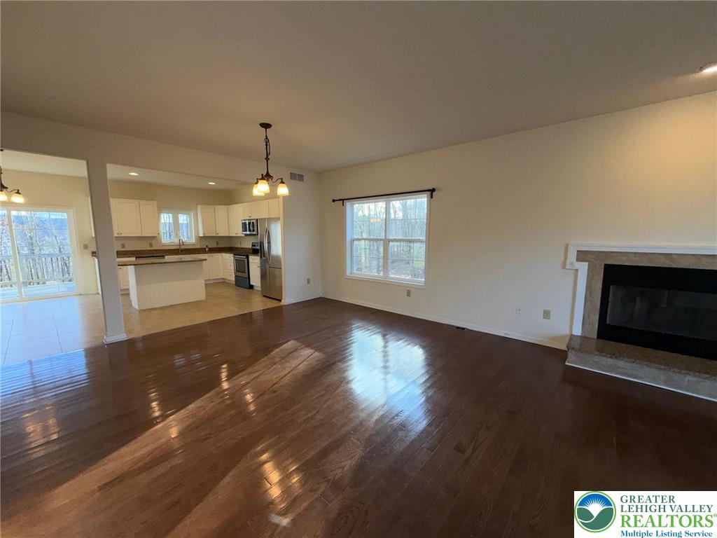 106 Hilda Court East Stroudsburg, PA 18301 - Photo 11 of 33 an empty room with wooden floor fireplace and windows