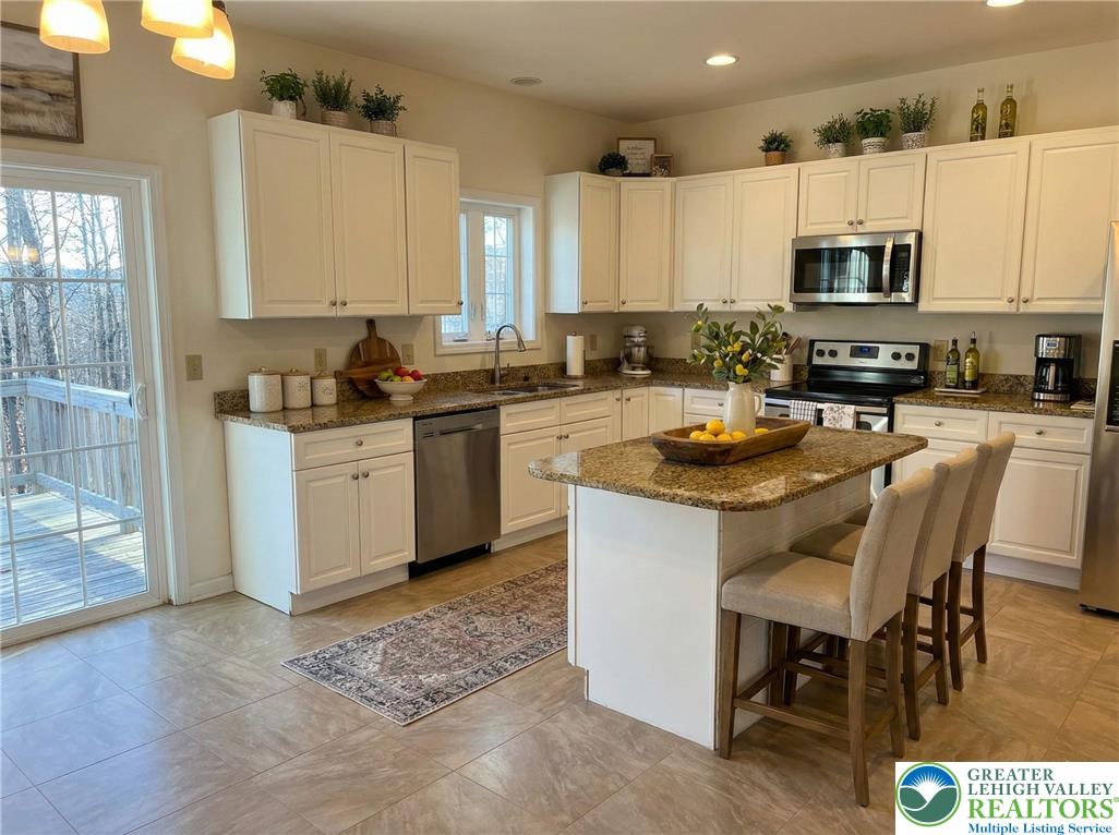 106 Hilda Court East Stroudsburg, PA 18301 - Photo 10 of 33 a kitchen with stainless steel appliances granite countertop a stove top oven a sink a dining table and chairs