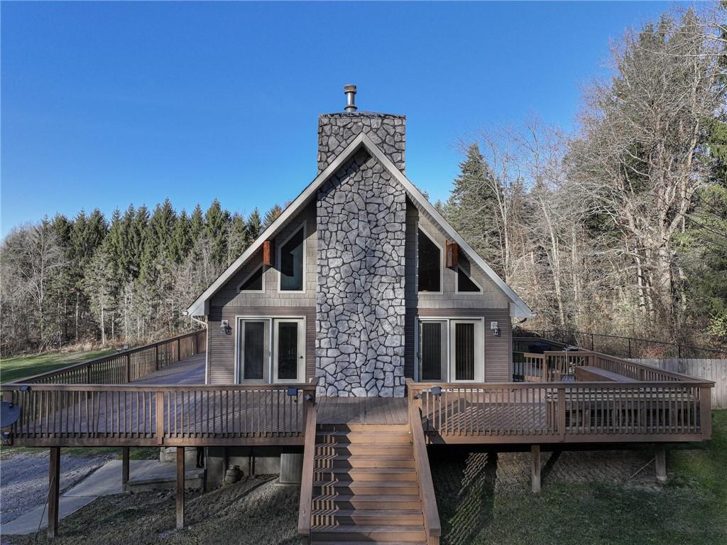 a view of house with wooden deck and furniture
