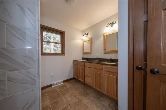 a bathroom with a granite countertop sink mirror and vanity
