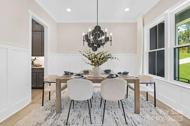 a dining room with furniture a chandelier and wooden floor