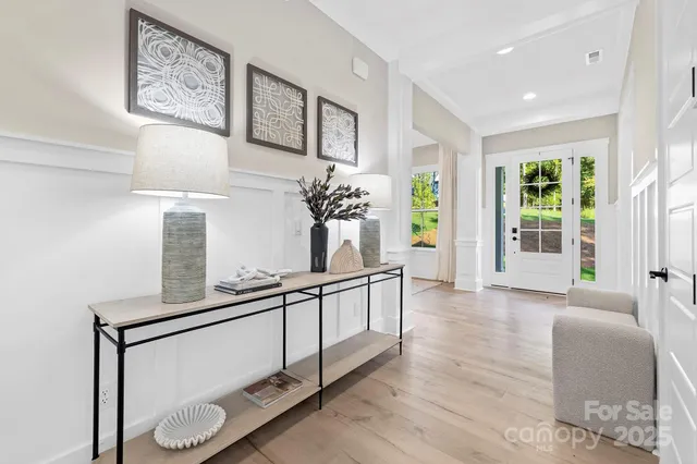 a room with lots of white furniture and a window