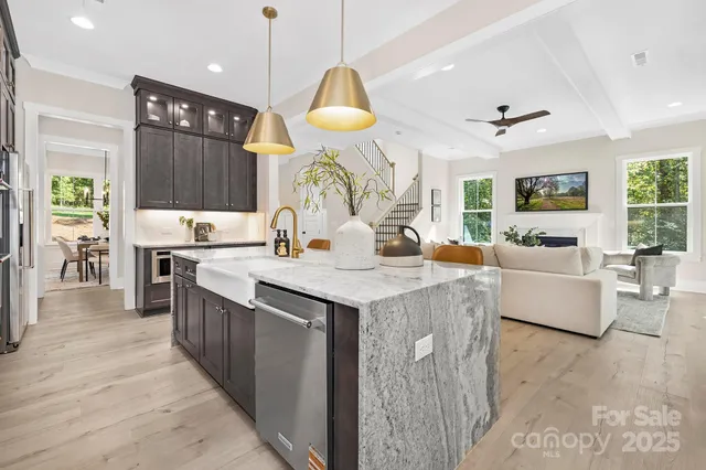 a kitchen with granite countertop a stove a sink a oven and a refrigerator