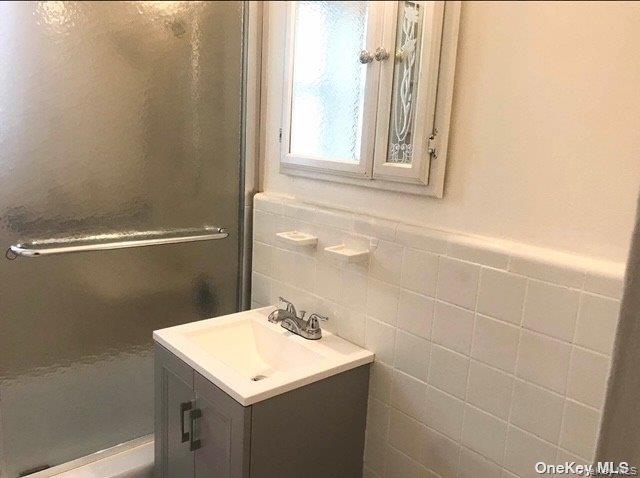81-15 35th Avenue, Unit 6 Queens, NY 11372 - Photo 7 of 7 a bathroom with a sink a toilet and a mirror