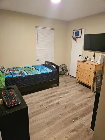 a bedroom with a bed and flat tv screen on the dresser