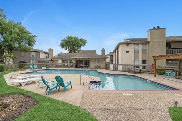 a view of a house with pool lawn chairs and a fire pit