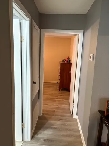 a view of a hallway with wooden floor and stairs