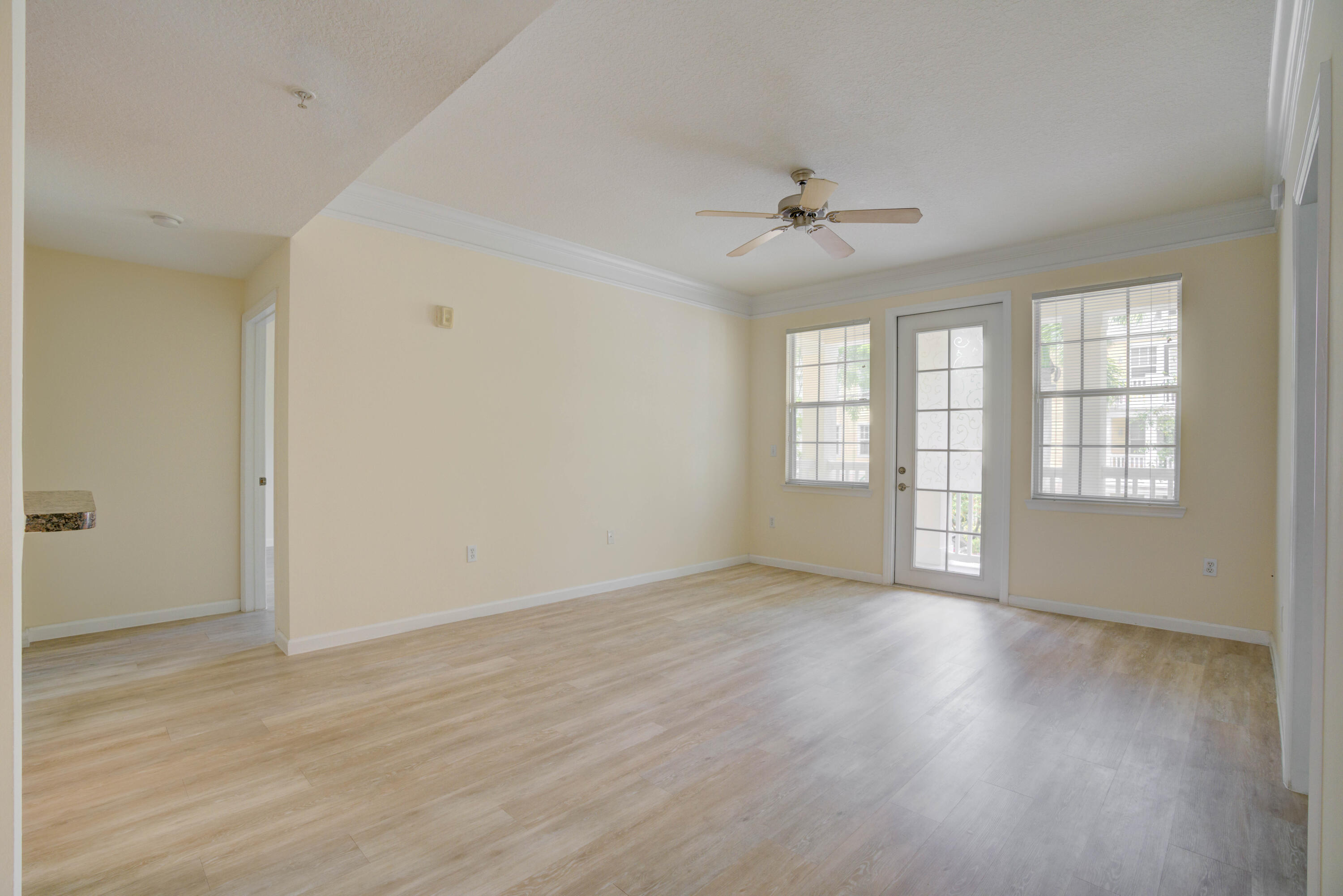 224 Murcia Drive, Unit 201 Jupiter, FL 33458 - Photo 11 of 36 an empty room with wooden floor ceiling fan and windows