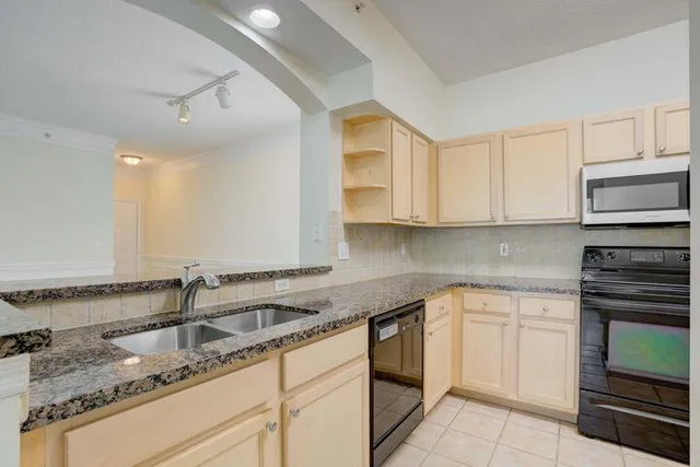 a kitchen with granite countertop white cabinets and stainless steel appliances