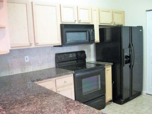 224 Murcia Drive, Unit 201 Jupiter, FL 33458 - Photo 17 of 36 a kitchen with stainless steel appliances granite countertop a stove microwave and refrigerator
