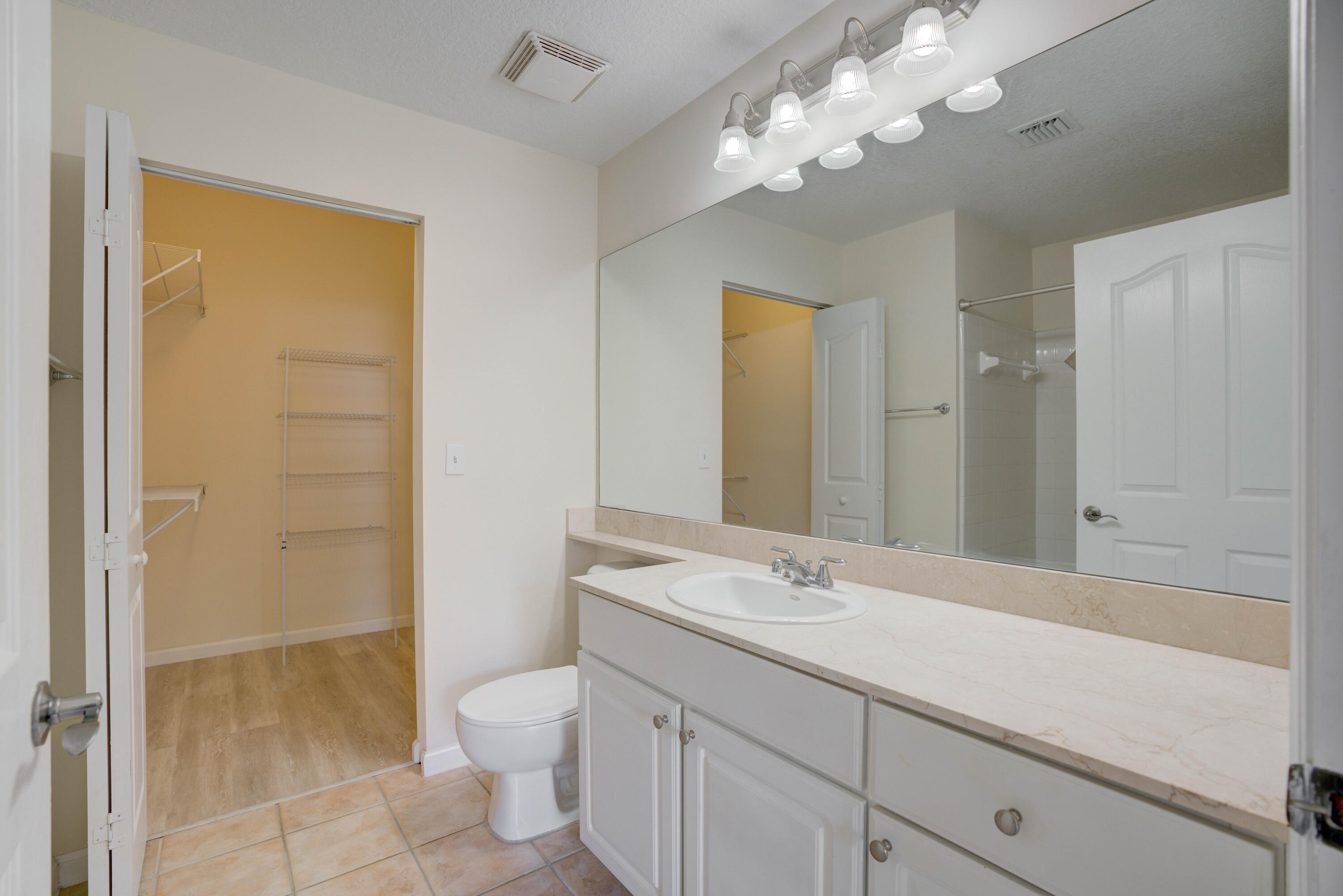 224 Murcia Drive, Unit 201 Jupiter, FL 33458 - Photo 18 of 36 a bathroom with a sink a toilet and a large mirror