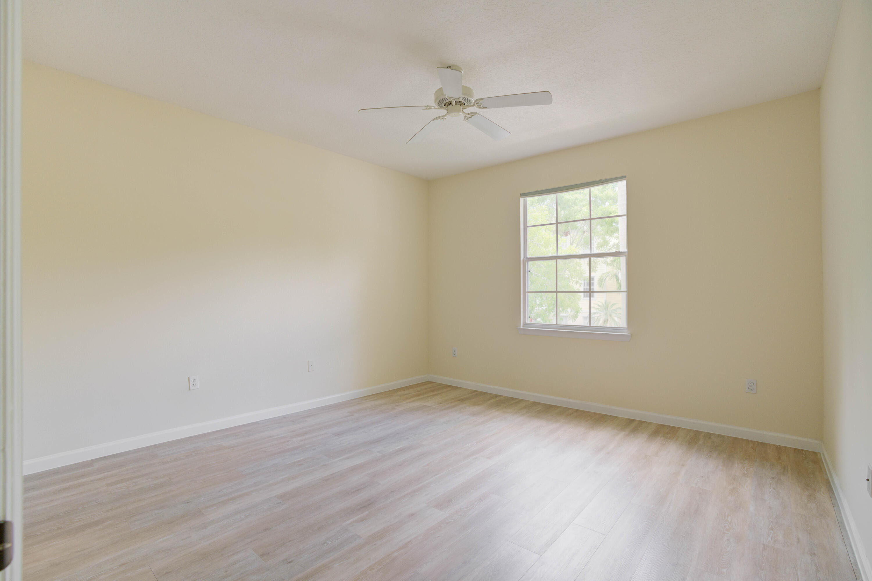 224 Murcia Drive, Unit 201 Jupiter, FL 33458 - Photo 21 of 36 an empty room with wooden floor fan and windows