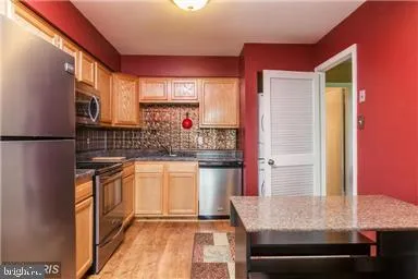 a kitchen with stainless steel appliances granite countertop a sink and a refrigerator