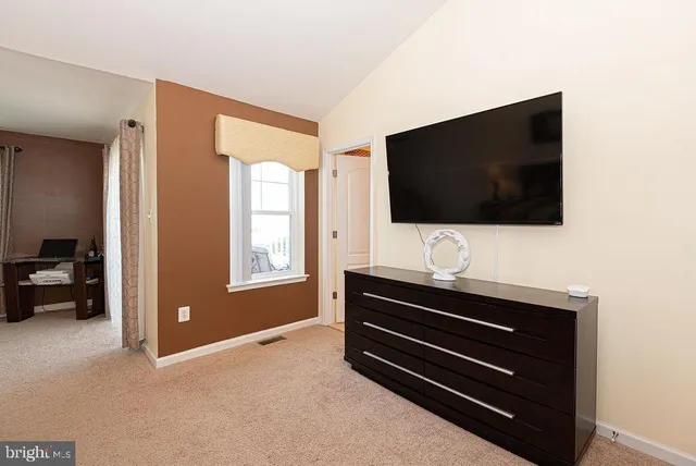 a bedroom with a bed and a lamp on dresser