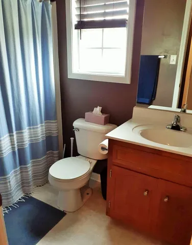 a bathroom with a toilet sink and mirror