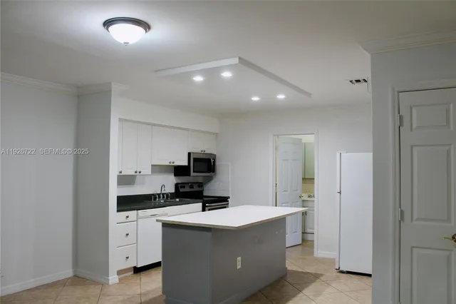 a kitchen with stainless steel appliances granite countertop white cabinets and a stove