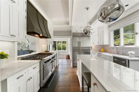 a kitchen with stainless steel appliances granite countertop a sink a stove and a refrigerator