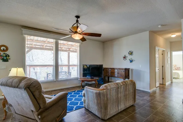 a living room with furniture a flat screen tv and a large window