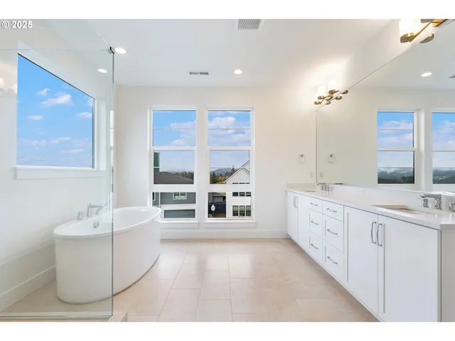 a white tub sitting next to a bathroom