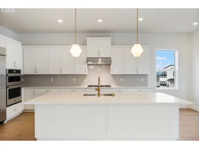 a kitchen with kitchen island white cabinets and stainless steel appliances