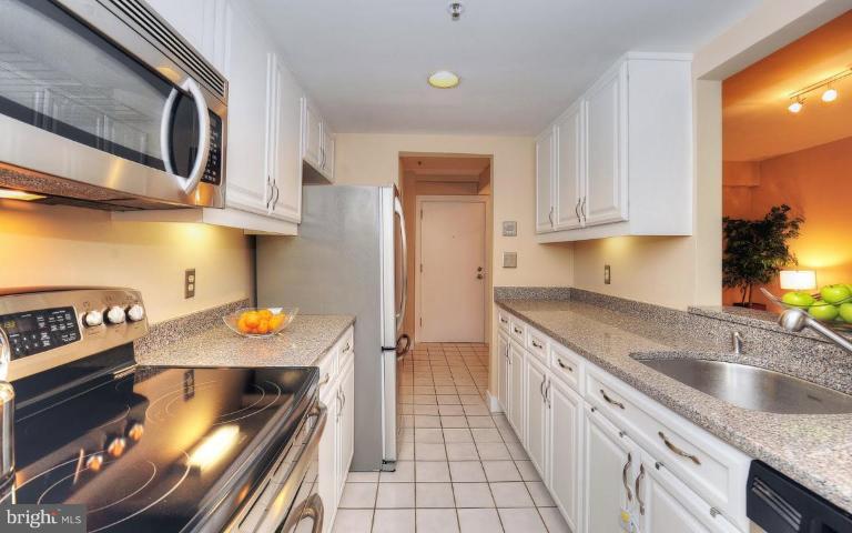1727 R Street Northwest, Unit 104 Washington, DC 20009 - Photo 3 of 14 a kitchen with stainless steel appliances granite countertop a stove a sink and a microwave