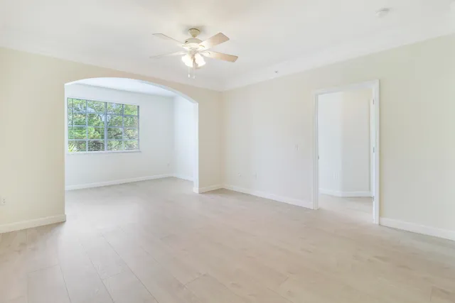 an empty room with windows and fan