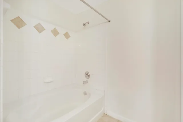 a white bath tub sitting next to a white wall