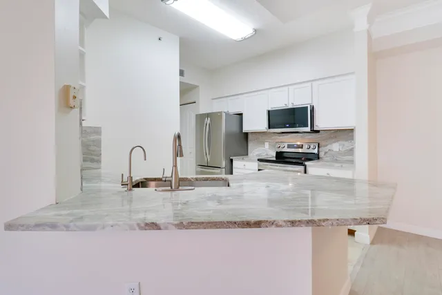 a kitchen with granite countertop a sink a stove and a granite counter top