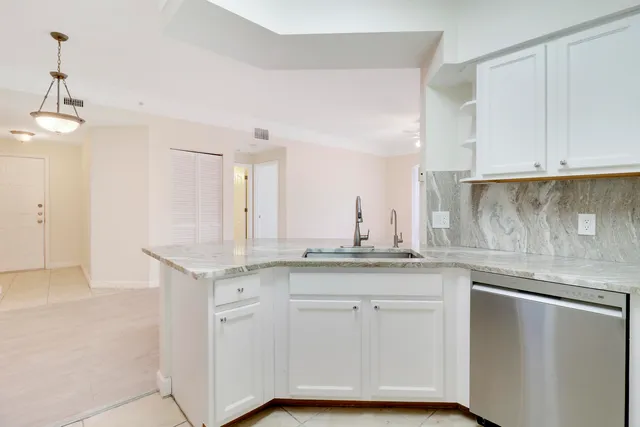 a kitchen with granite countertop white cabinets and a sink